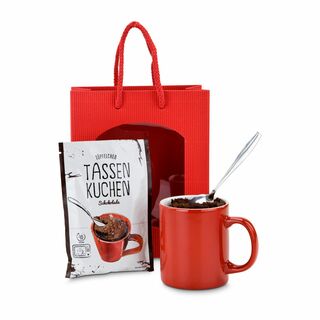 Schnell und lecker: ein Kuchen für zwischendurch - eine rote Geschenktüte, eine rote Tasse und eine Backmischung für einen Tassenkuchen.