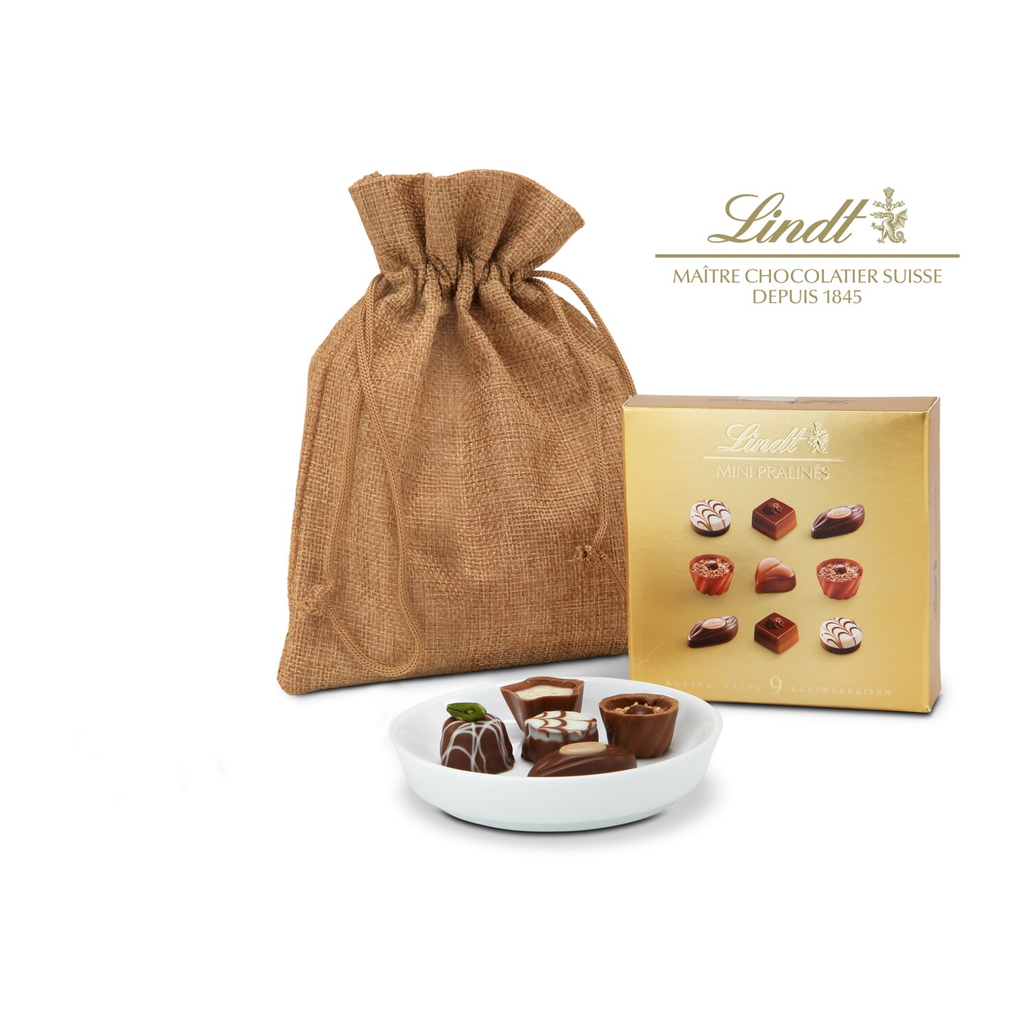 Eine edle Porzellanschale (ca. ø 10 cm) und dazu 9 kleine Lindt Mini Pralinés (44 g) verpackt in einem Jutesäckchen.